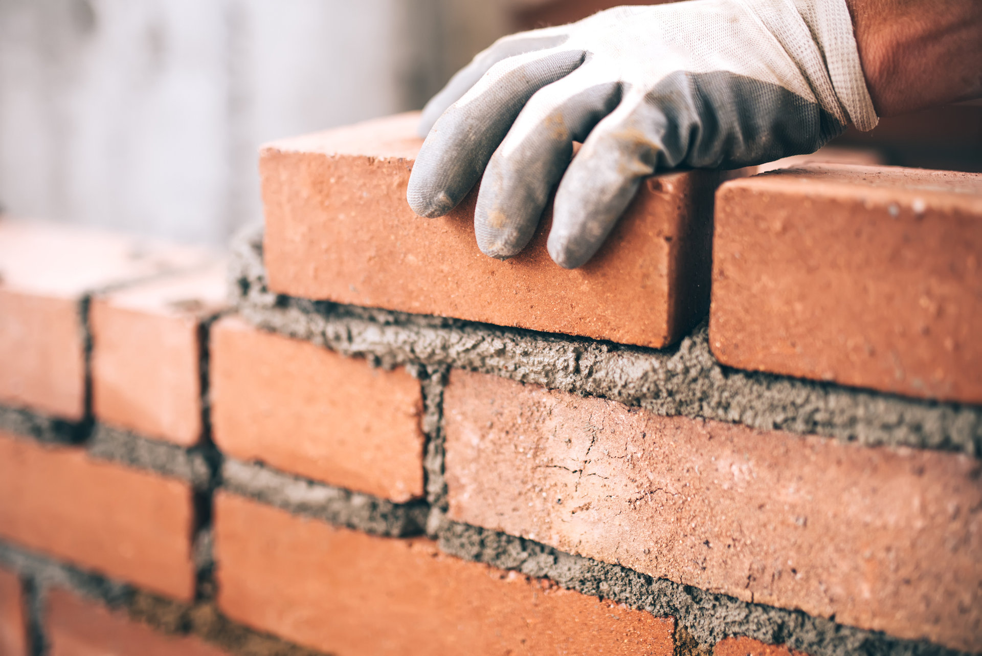 622800884 Close up of industrial bricklayer installing bricks on construction site